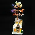 Multi-colored chakra gemstone crystal money tree on warm glowing LED snow cottage. - European Snow House