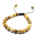 Detail view of 8mm natural stone beads on a brown adjustable hand-woven cord bracelet. - Jasper