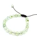 Macro detail of 8mm natural prehnite stone beads on a brown woven adjustable bracelet - Prehnite