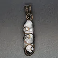 Close-up of handmade wire wrapped natural clear quartz crystal pendant on dark background - Clear Quartz (Bronze-tone Wrapped)