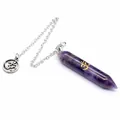 Close-up of a hexagonal amethyst crystal pendulum featuring a golden Om symbol engraving. - Amethyst