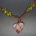 Detail of a handmade rose quartz pendant necklace in a brown woven net with peridot stones. - Hand-Woven Net Pouch / Rose Quartz