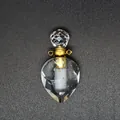 Macro detail of faceted clear crystal heart perfume bottle pendant with gold hardware. - White Crystal