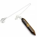 Close-up of Tiger's eye hexagonal crystal pendulum pendant with golden Om symbol - Tiger's Eye