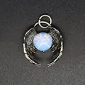 Detailed close-up of a vintage silver angel wings pendant featuring a glowing blue opalite bead - Opal