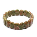 Detailed macro view of a natural Unakite stone stretch bracelet with flat oval beads. - Faceted Panel Style / Unakite