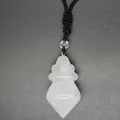 Detail of a white crystal conical pendant with a black braided cord on a grey background. - White Crystal