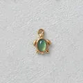 Detailed macro view of a gold-plated turtle pendant featuring a green oval gemstone inlay - M / Light Green Turtle