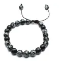 Macro view of 8mm snowflake obsidian natural stone beads on a handmade braided bracelet. - Snowflake Obsidian
