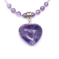 Detailed close-up view of a heart-shaped purple amethyst pendant on a beaded necklace - Amethyst