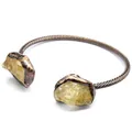 Detailed macro shot of vintage copper open cuff bracelet with raw yellow citrine stones - Citrine