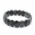 Close-up detail of a natural grey speckled stone faceted bead stretch bracelet for women. - Larvikite