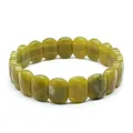 Detailed macro view of a fashionable natural yellowish-green stone faceted slab bracelet - Olive Jade