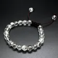 Detailed view of clear 8mm natural stone beads on a dark braided cord charm bracelet. - White Crystal
