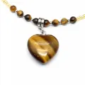 Macro detail of a natural heart-shaped tiger eye stone pendant on a beaded necklace - Tiger's Eye