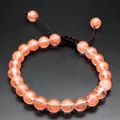 Handmade 8mm natural orange stone bead bracelet featuring an adjustable woven cord closure - Watermelon red