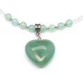 Macro detail of a heart-shaped green natural stone pendant on a beaded necklace strand - Aventurine Jade