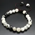 Detailed view of 8mm natural stone beads with unique black and white patterns on a woven bracelet - Black Rutilated Quartz