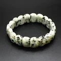 Macro detail of natural faceted Dalmatian Jasper stone beaded bracelet on black surface - Sky Blue