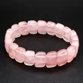 Macro view of a polished rose quartz rectangle bead bracelet on a dark background. - Rose Quartz
