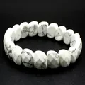 Macro shot of a white faceted howlite bracelet with gray veins on black background - Howlite