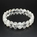 Vue détaillée d'un bracelet en perles de cristal blanc naturel sur un fond noir texturé. - Cristal blanc