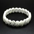 Vue détaillée d'un bracelet en pierre de howlite blanche facettée sur fond noir texturé - Howlite