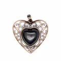 Close-up detail of vintage style hollow heart pendant featuring a polished black stone - Obsidian