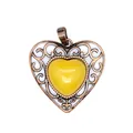 Macro view of vintage bronze hollow heart pendant with yellow natural stone - Topaz