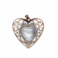 Close-up detail of a vintage bronze hollow heart pendant with a natural stone center - Labradorite