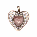 Close-up detail of vintage hollow heart pendant with central red natural stone inlay - Strawberry Quartz