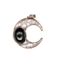 Detail shot of an antique bronze crescent moon pendant featuring a black natural stone - Obsidian