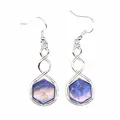Close-up of hexagonal blue stone earrings with elegant twisted silver-tone metal wire - Lapis Lazuli