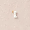 Makro-Detail des weißen Emaille-Knochenanhängers mit vergoldetem Edelstahlring für Schmuck - Weißer Knochen