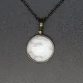 Dettaglio ravvicinato di una collana vintage minimalista con ciondolo tondo in pietra naturale bianca - Howlite