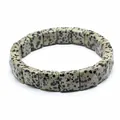 Detailed close-up view of a natural dalmatian stone square bead stretch bracelet - Dalmatian Jasper