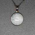 Macro detail of a natural white stone pendant with retro metal wrap design on chain. - White Crystal