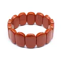 Detailed macro view of natural red stone hand row stretch bracelet with polished oval beads - Red Jasper