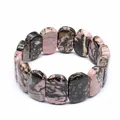 Macro view of polished Rhodonite natural stone bracelet with unique pink and black patterns. - Rhodonite