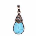 Macro view of vintage teardrop pendant featuring blue turquoise-style stone and bronze filigree detail - Blue Turquoise