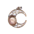 Close-up macro of an antique hollow crescent moon pendant with a glowing iridescent stone - Watermelon red