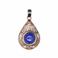 Exquisite close-up of a vintage hollow teardrop pendant with blue natural stone inlay - Lapis Lazuli