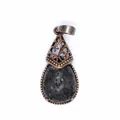 Close-up of vintage teardrop-shaped pendant featuring black lava stone and filigree - Lava Stone