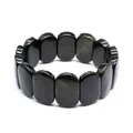 Close-up of natural black stone bracelet with oval tiles and subtle golden flash - Golden Sheen Obsidian