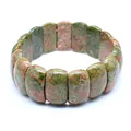 Close-up of a natural unakite stone bracelet with green and pink patterns on white background. - Unakite