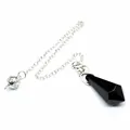 Macro view of a hexagonal black stone pendulum pendant with a silver chain decoration - Obsidian