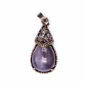 Detailed macro view of a vintage teardrop purple natural stone pendant with bronze filigree. - Amethyst