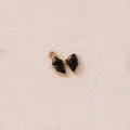 Nahaufnahme eines schwarz emaillierten vergoldeten Schleifenanhängers für DIY-Schmuck. - Schwarze kleine Schleife