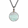 Close-up detail of a round light green natural stone pendant with a vintage metal frame - Rainbow Fluorite