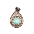 Macro close-up of a vintage teardrop pendant with hollow patterns and a green gemstone. - Amazonite